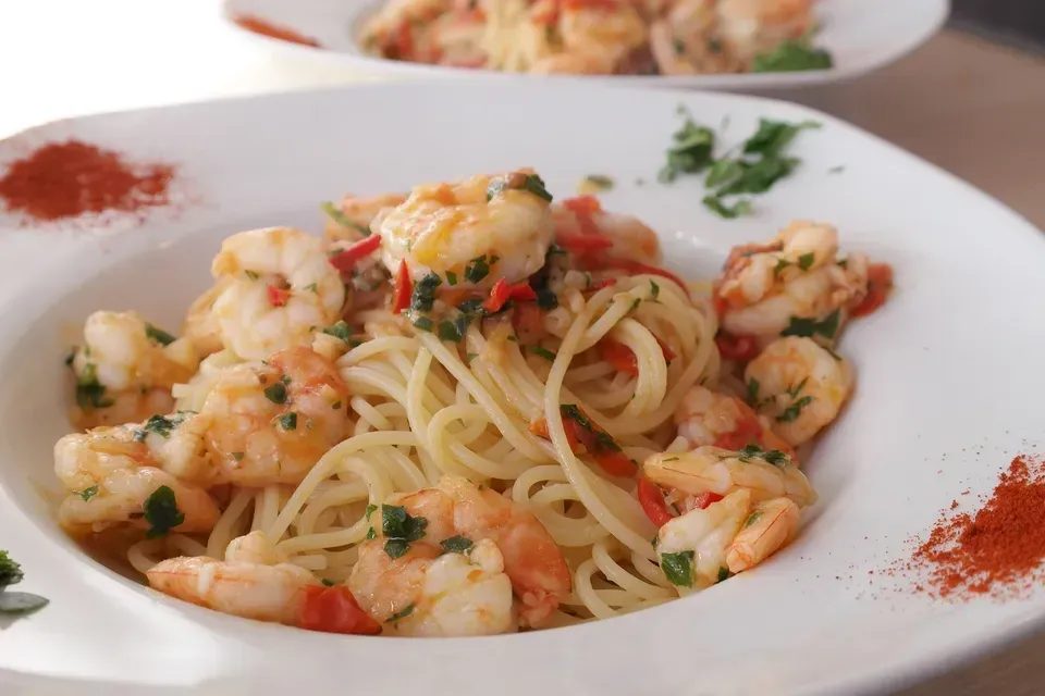 A close up of a plate of shrimp scampi on a table
