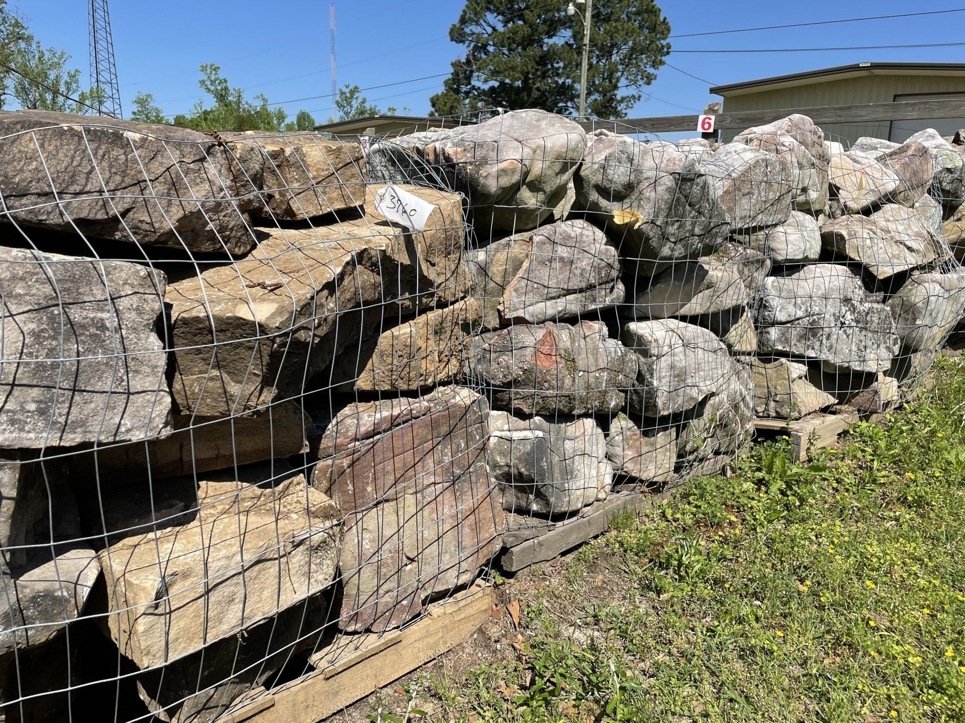 Stone wall held together by wire mesh, outdoors.