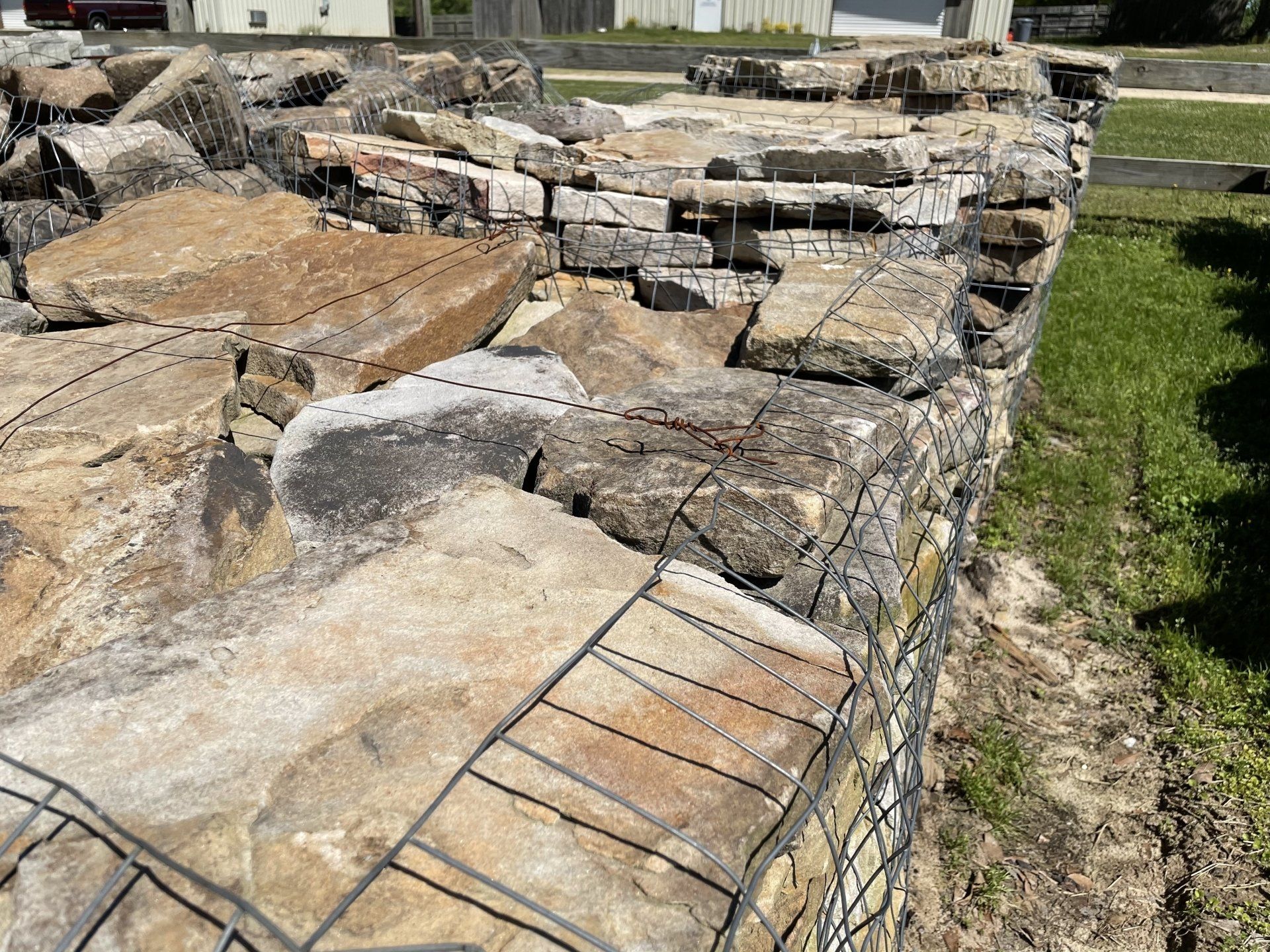 Stone wall made of rocks held together by wire mesh.