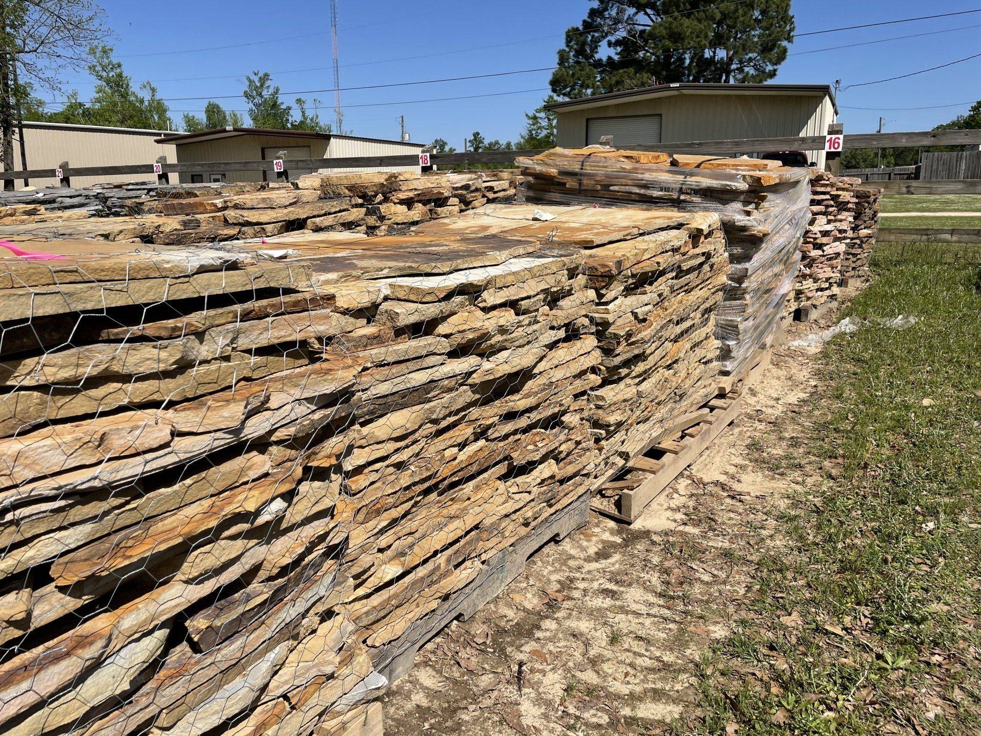 Stacks of natural stone paving slabs ready for sale, outdoors.