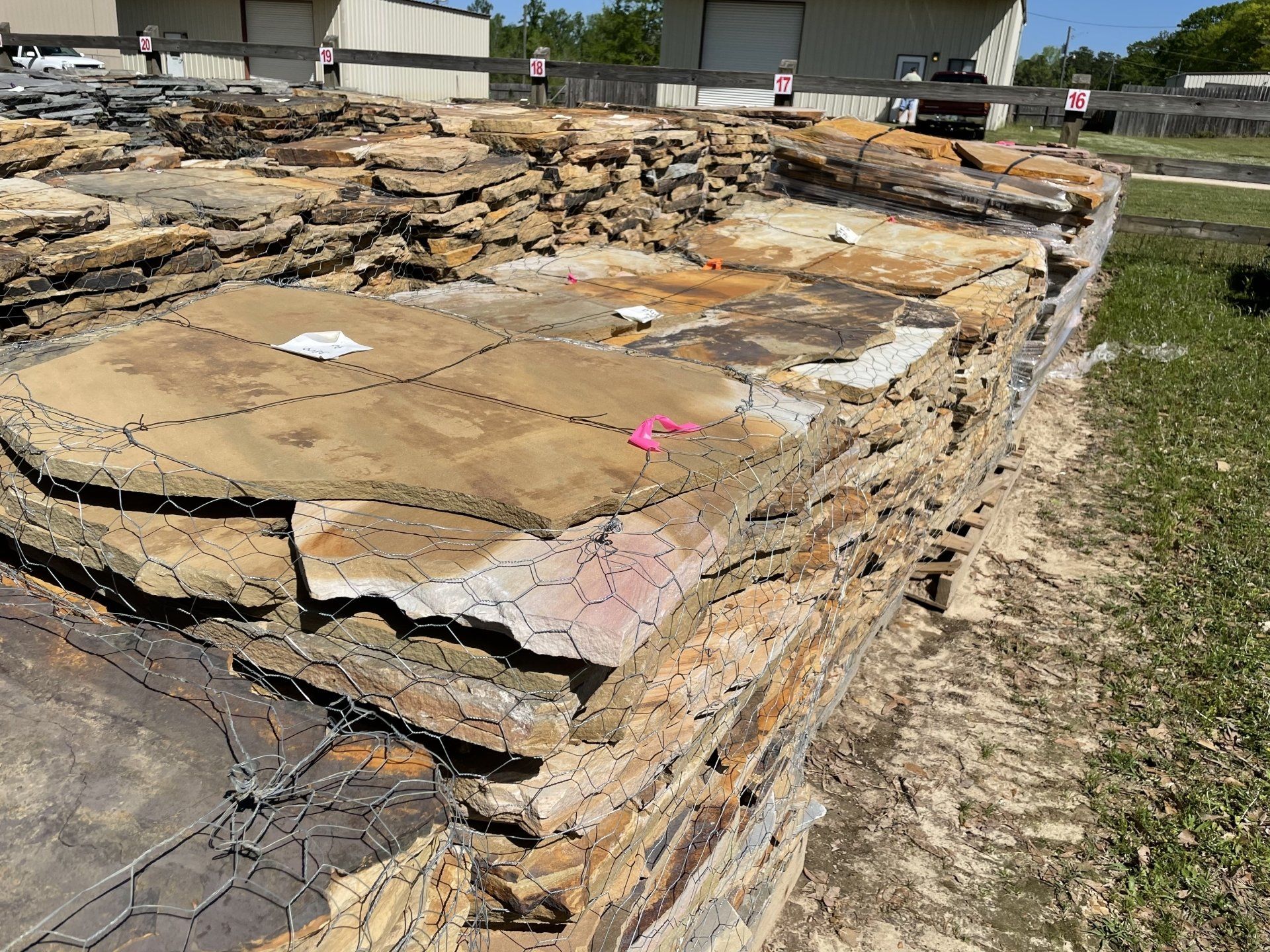 Stack of irregularly shaped brown and tan flagstone pavers outdoors.