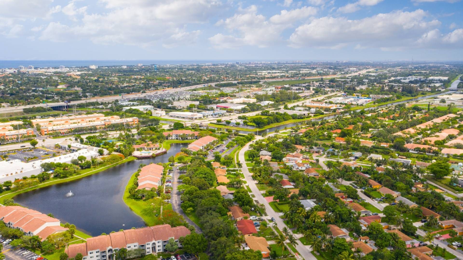 An aerial view of a residential area with a lake in the middle of it.