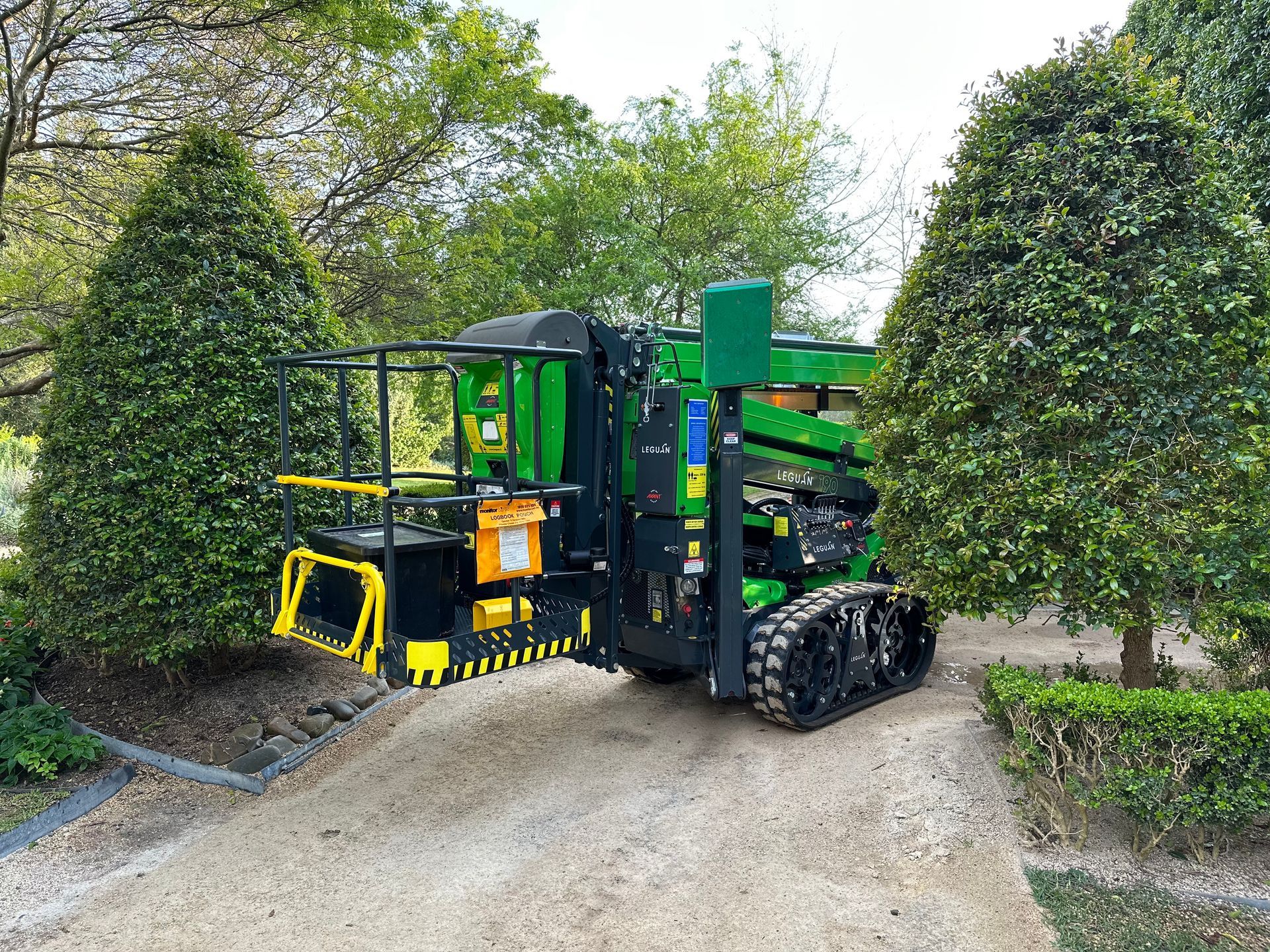 An Green Forklift Is Parked In A Garden — High Work Services in Hunter Valley, NSW