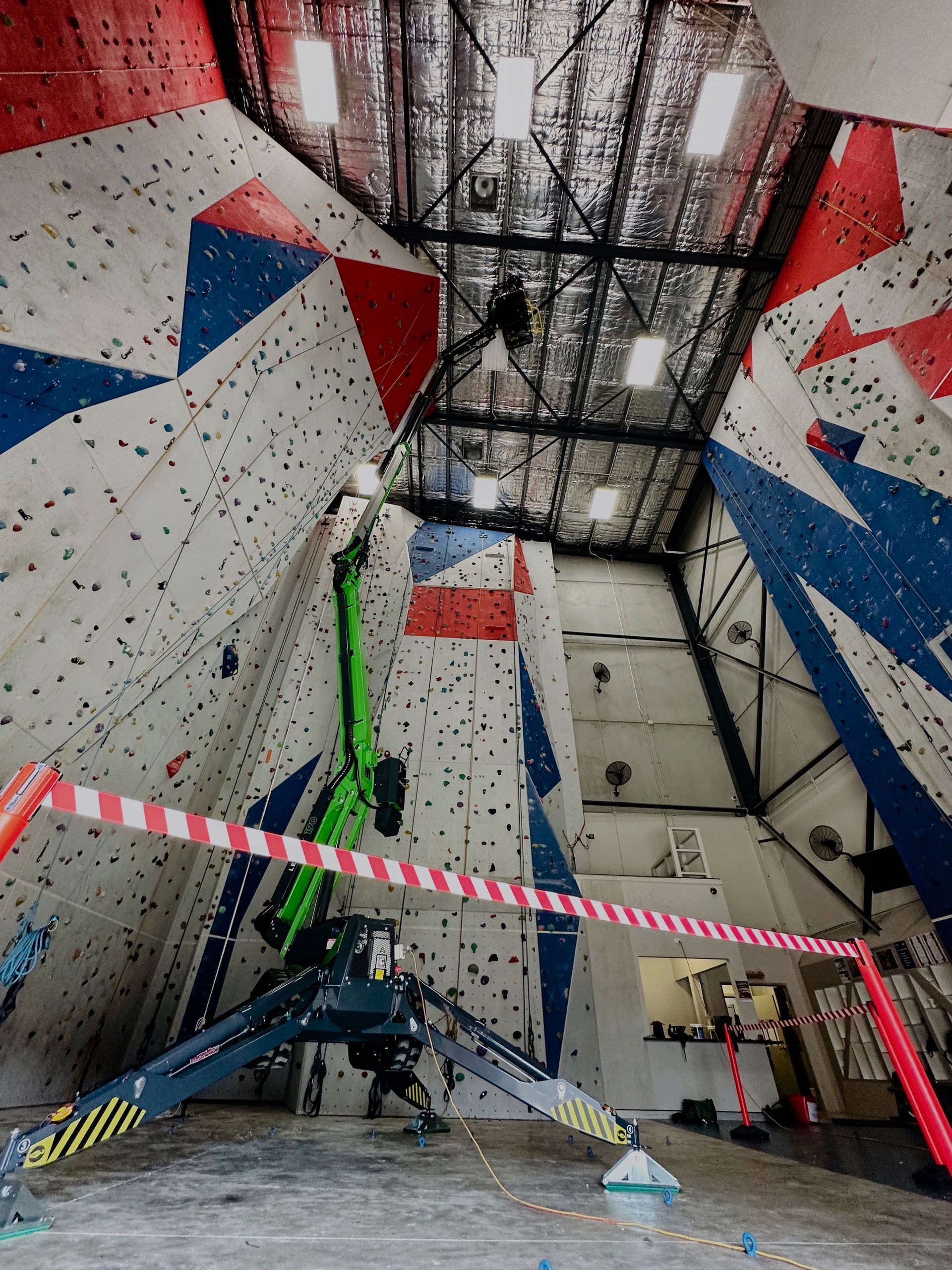A Green Crane Is Working On A Climbing Wall — High Work Services in Maitland, NSW