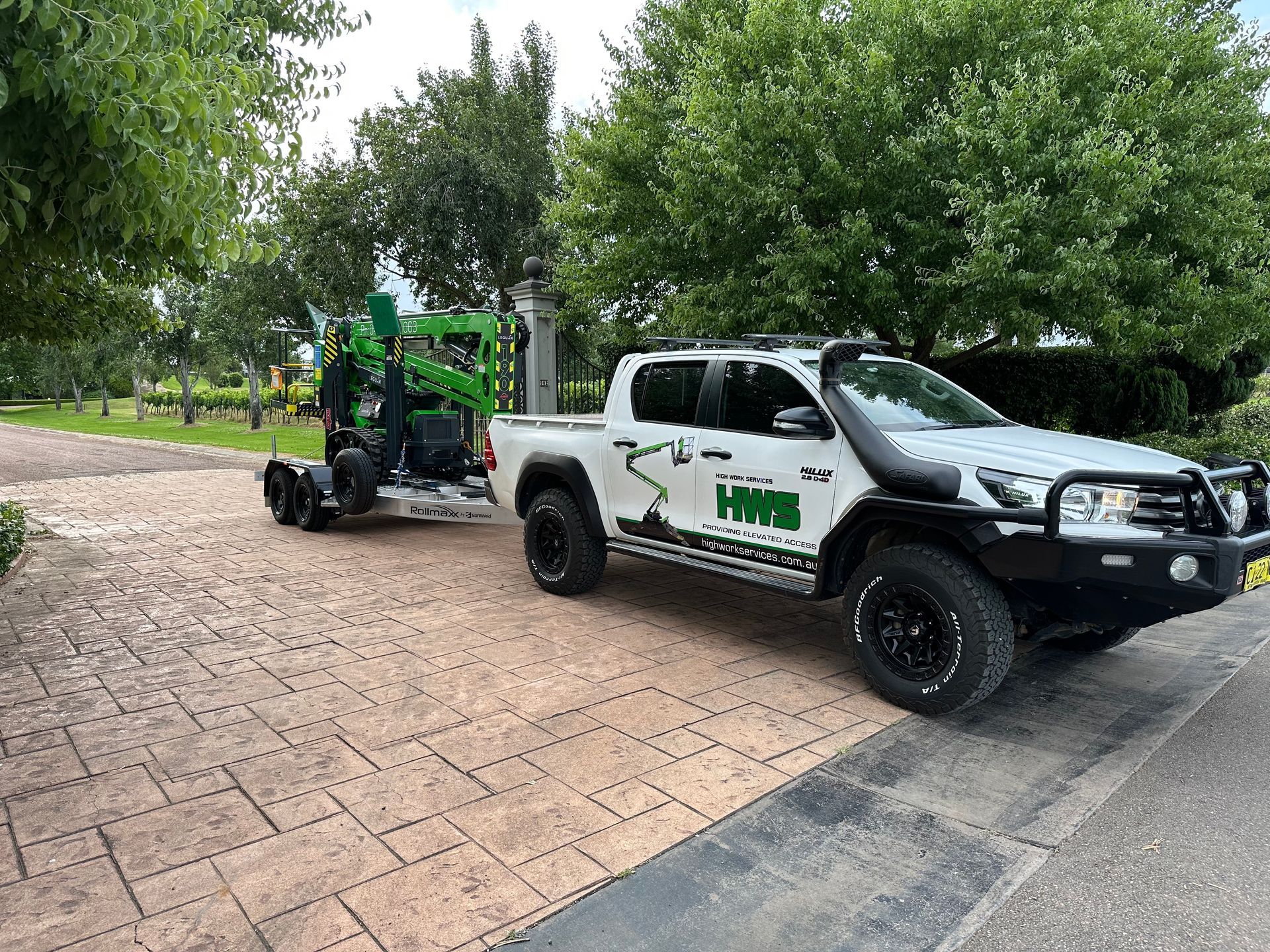 A Green Lift Is Being Pulled By A Car— High Work Services in Lake Macquarie, NSW