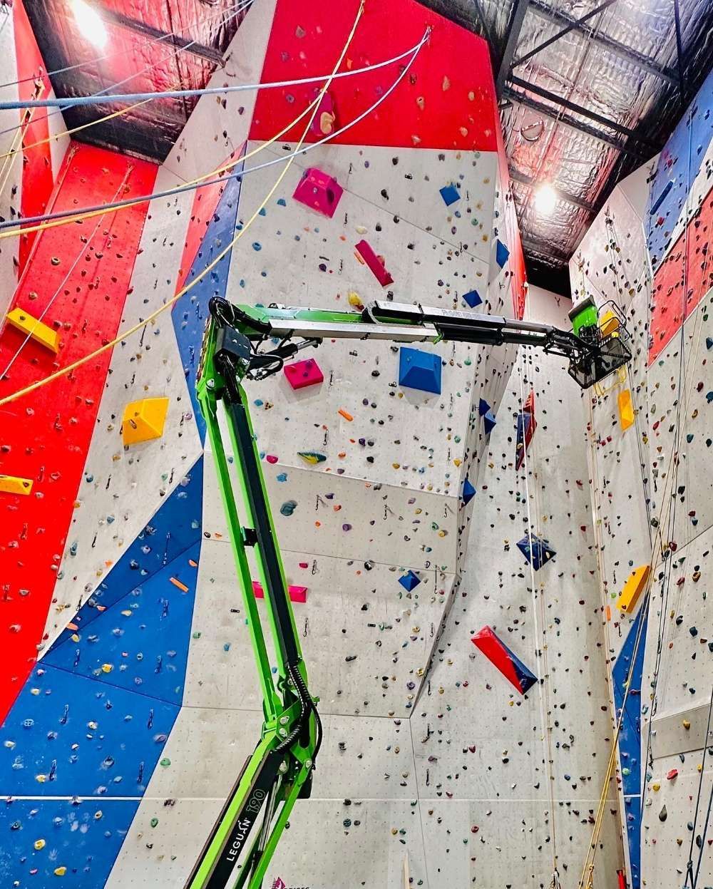 A Green Crane Is Working On A Climbing Wall — High Work Services in Maitland, NSW