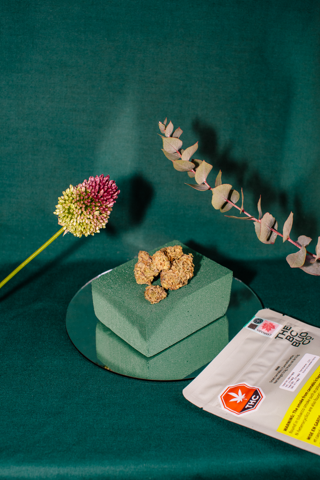There is a flower and a bag of food on the table.