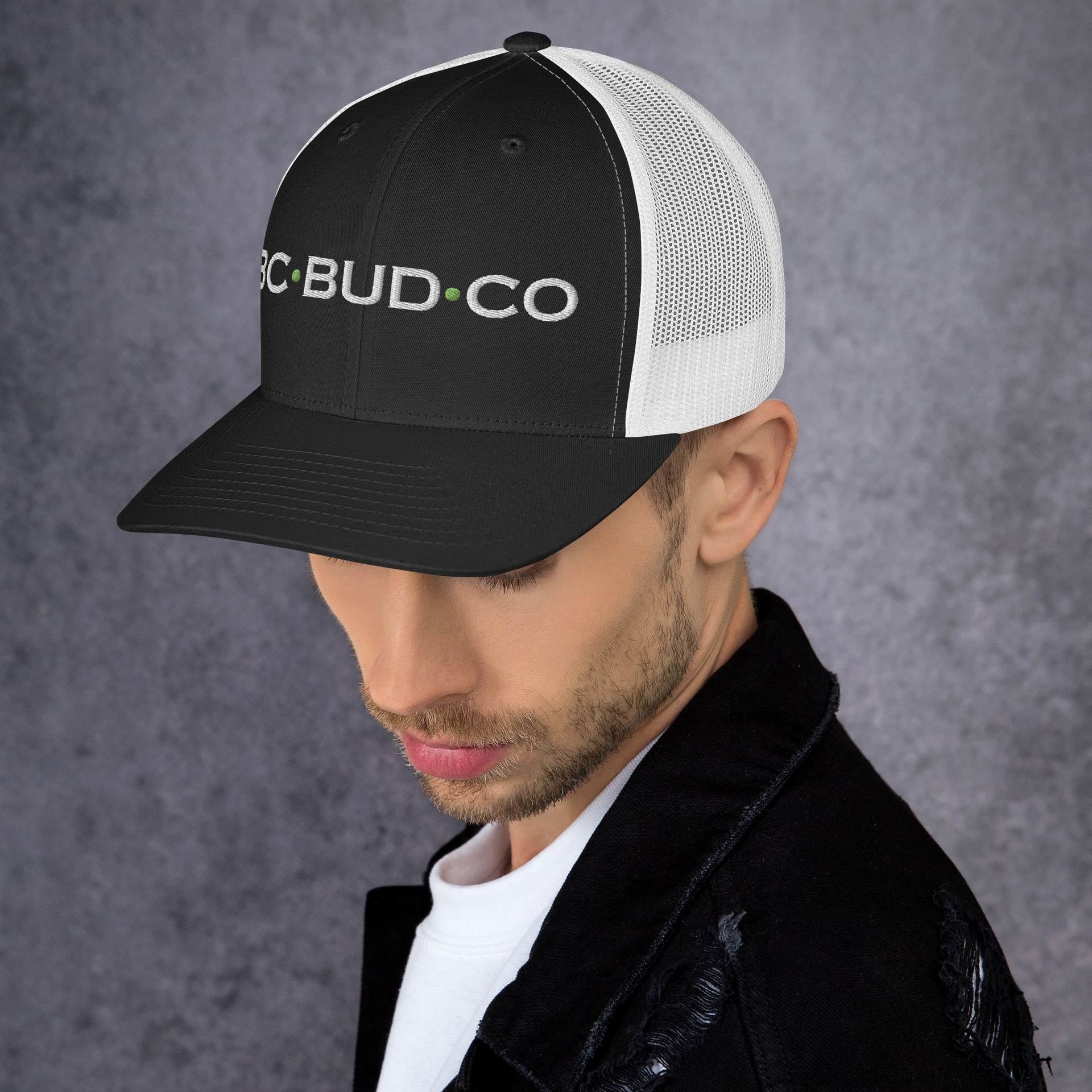 A man wearing a black trucker hat that says bud co