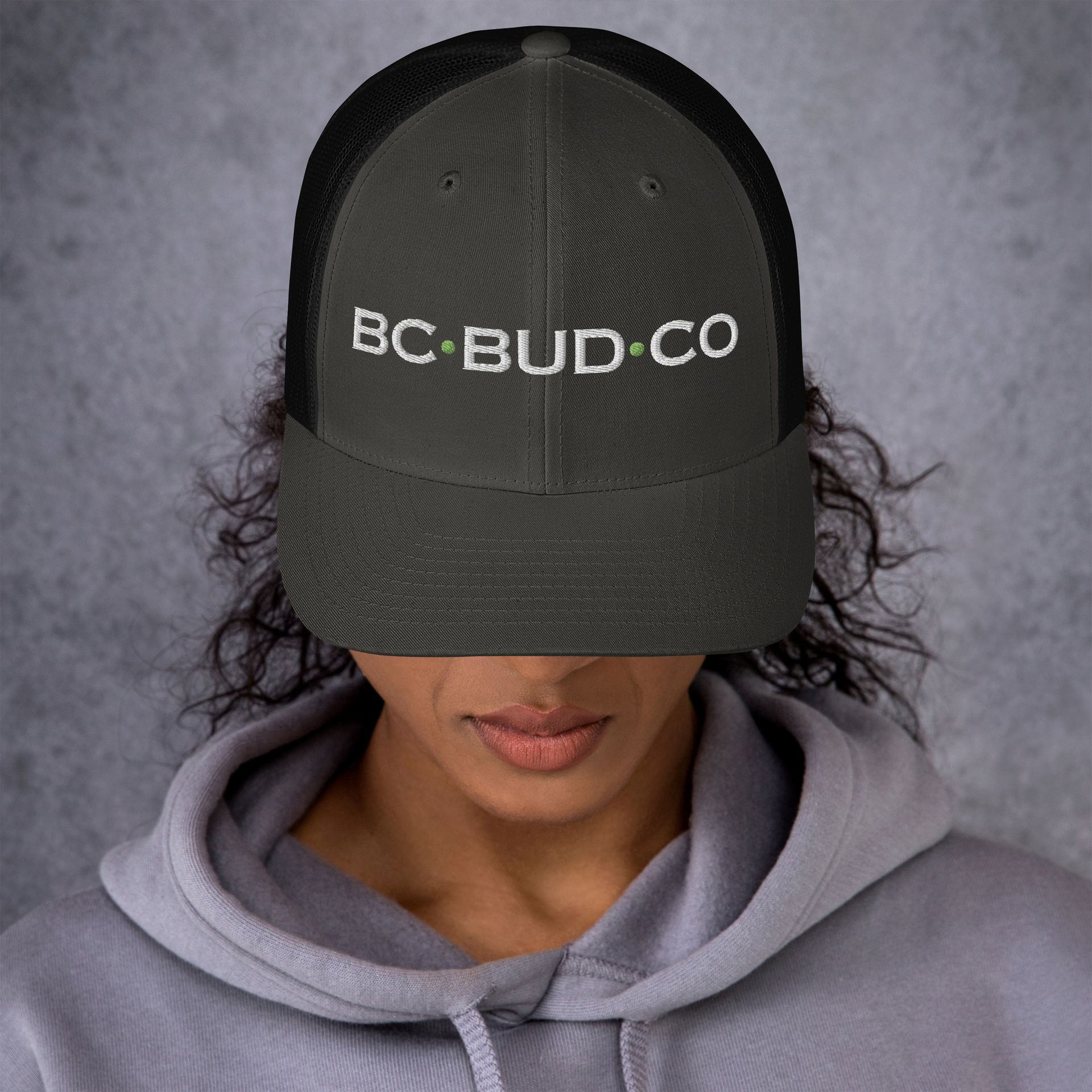 A woman is wearing a hat that says bc bud co