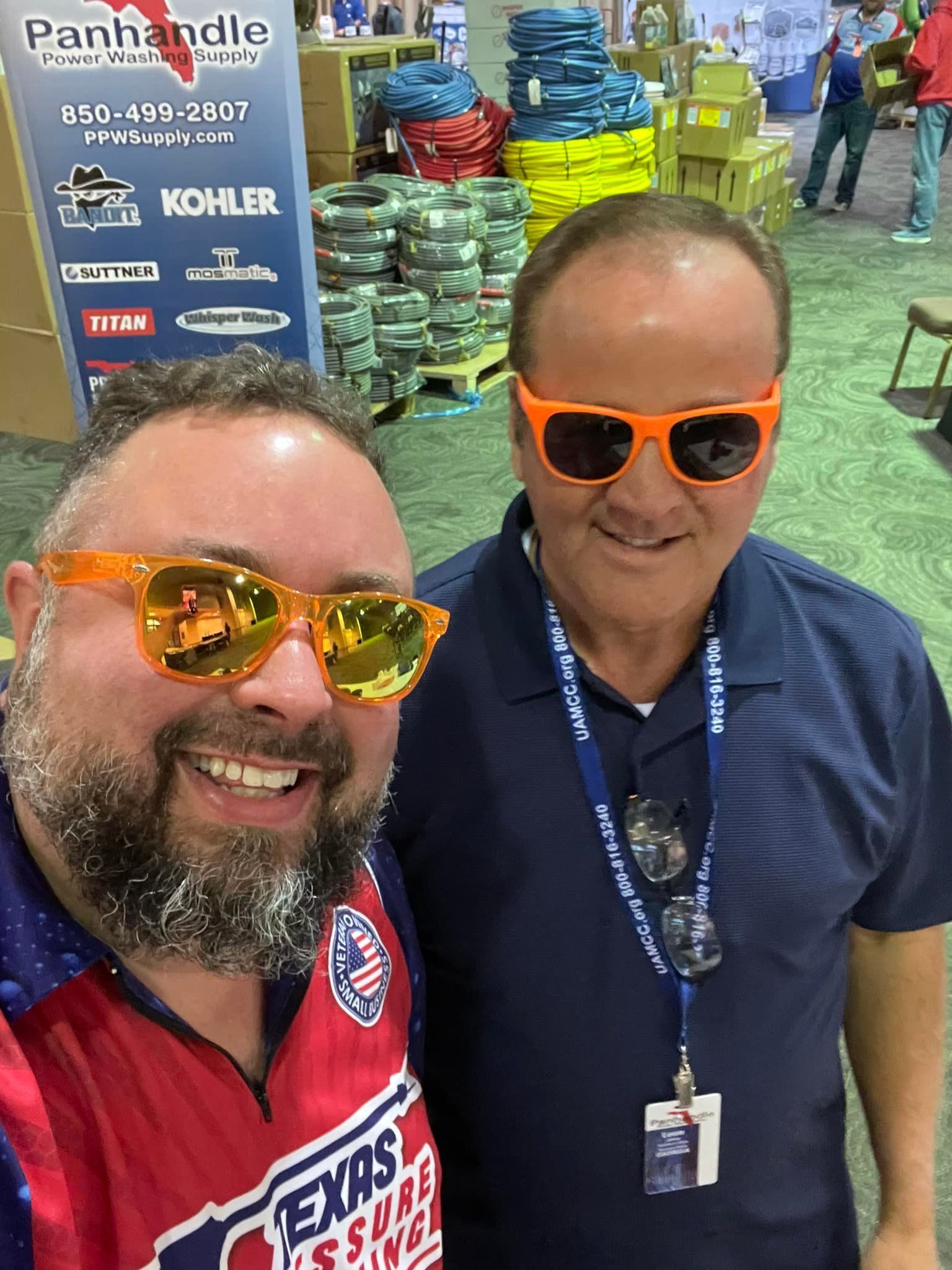Two men wearing sunglasses and a texas shirt are posing for a picture.