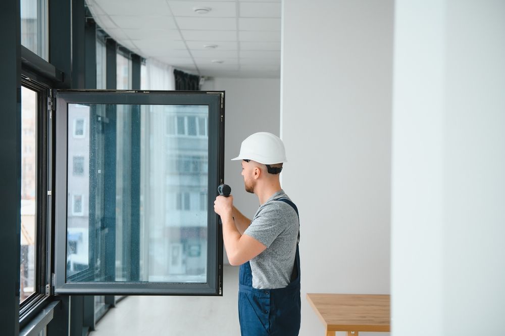Man in a Hard Hat Installing a Window in a Modern — Southside Glass & Aluminium in Smithfields, QLD