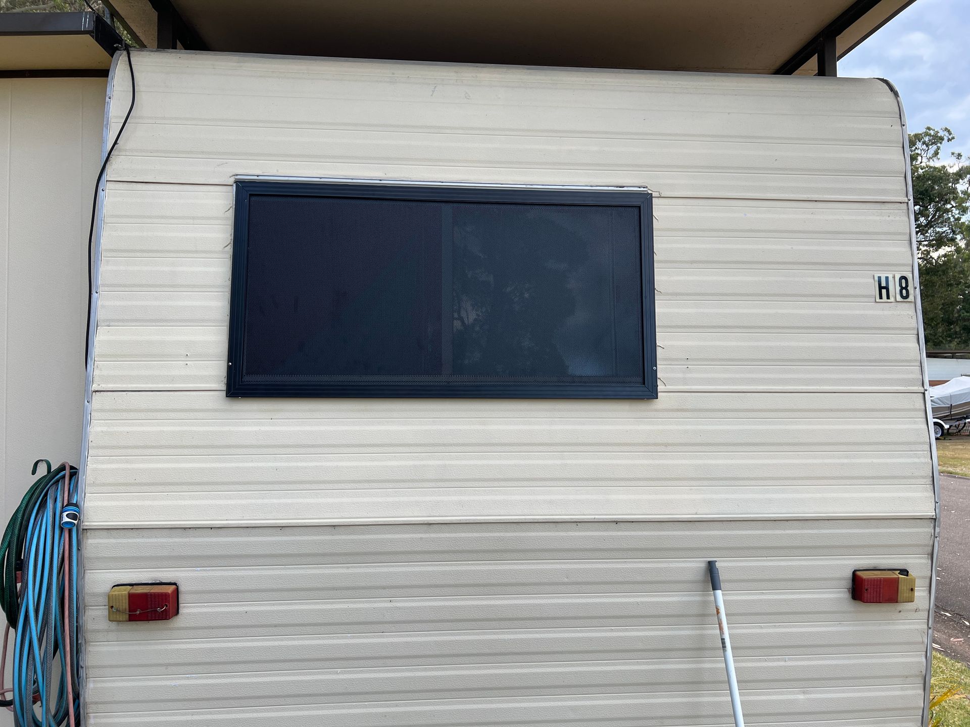 A White Trailer With a Black Window is Parked in Front of a House — Southside Glass & Aluminium In Bentley Park, QLD