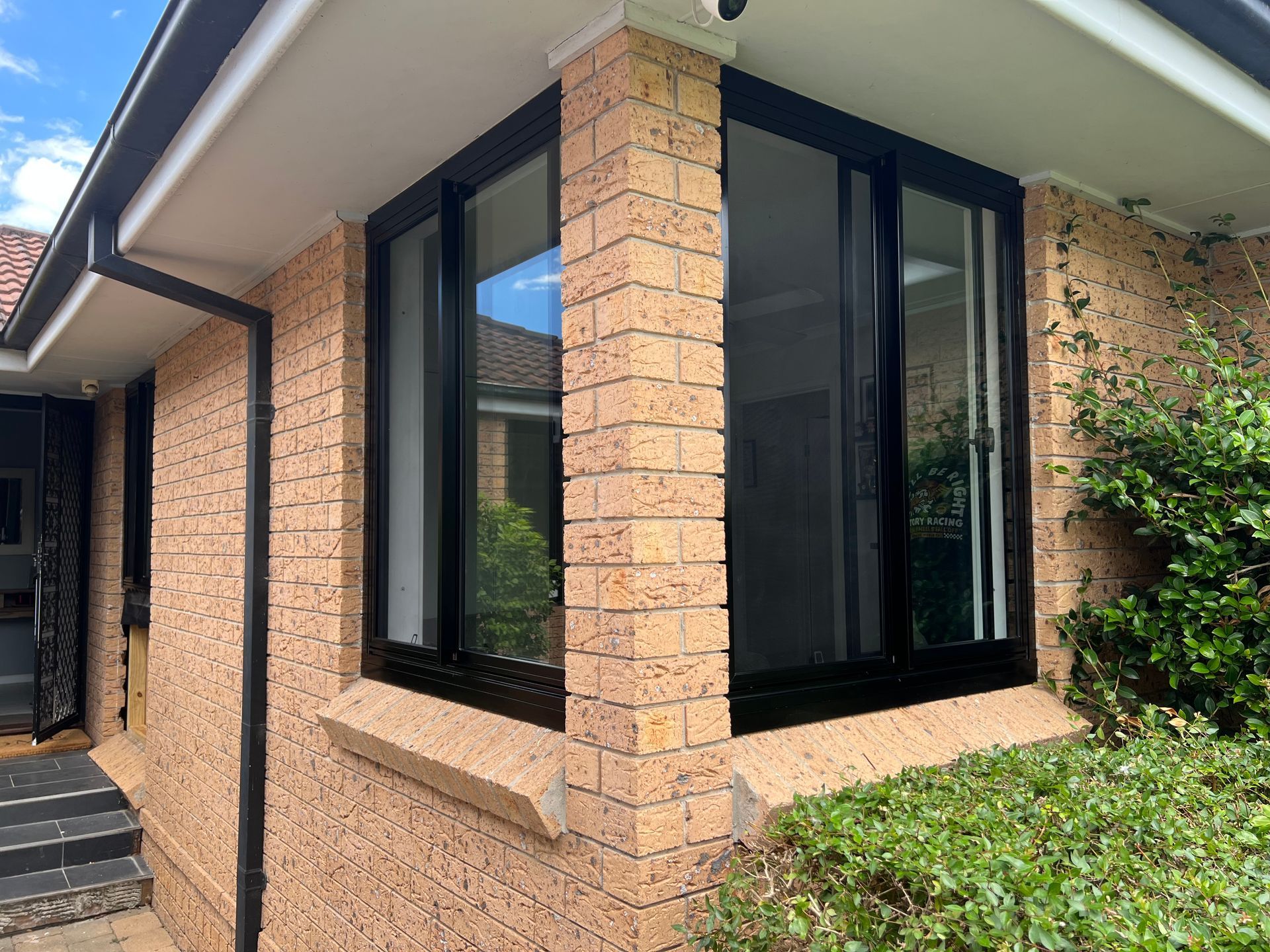 A Person is Putting a Piece of Foam Tape on a Window — Southside Glass & Aluminium In Bentley Park, QLD
