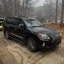 Black SUV parked on a wet driveway in a foggy, wooded residential area