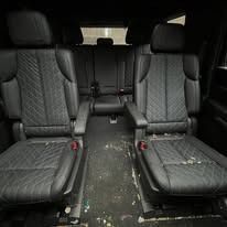 Black car interior with two front seats and a rear bench, all covered in gray patterned upholstery.