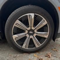Close-up of a car wheel with a silver and black alloy rim on a parked vehicle.
