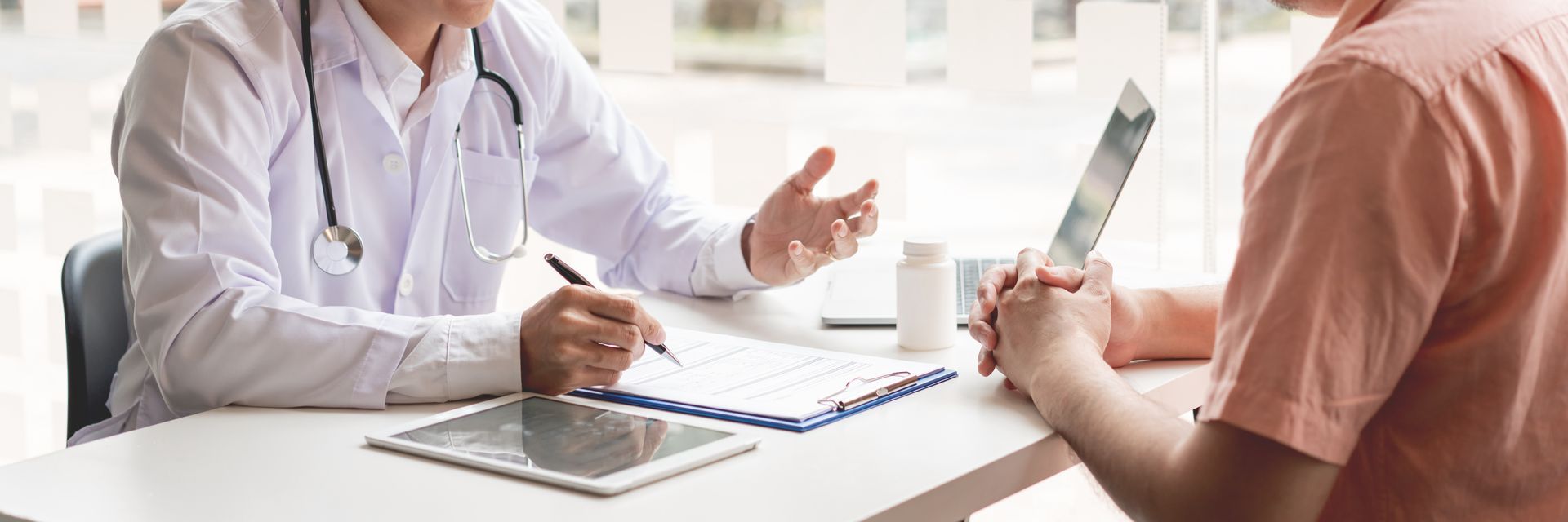 Patient listening a male doctor about diagnosis his symptoms after medical exam