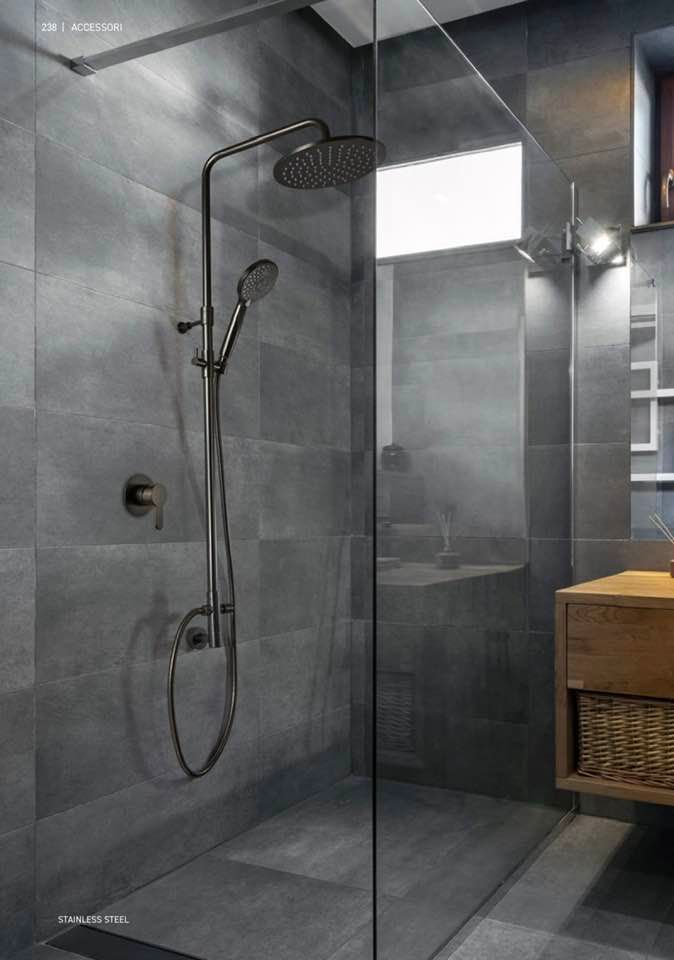 Bagno moderno con piastrelle grigie, cabina doccia in vetro e soffione a parete.