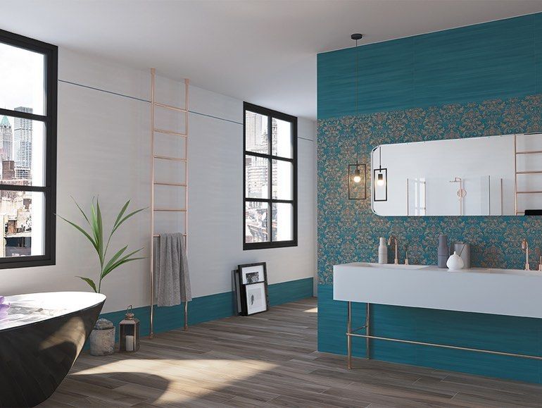 Bagno moderno con vasca bianca, parete decorativa color verde acqua, grande specchio e finestre con cornice nera.