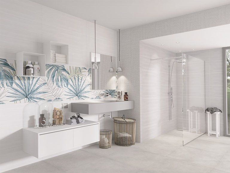 Bagno luminoso e bianco con decorazioni murali floreali blu, mensole sul lavabo e box doccia in vetro.