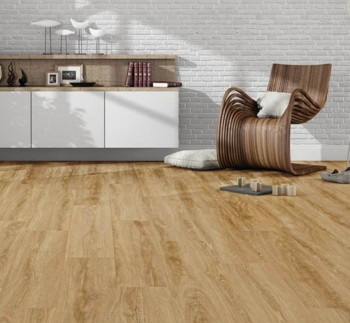 Soggiorno moderno con pavimento in legno, mobile bianco, poltrona a righe e parete in mattoni a vista.