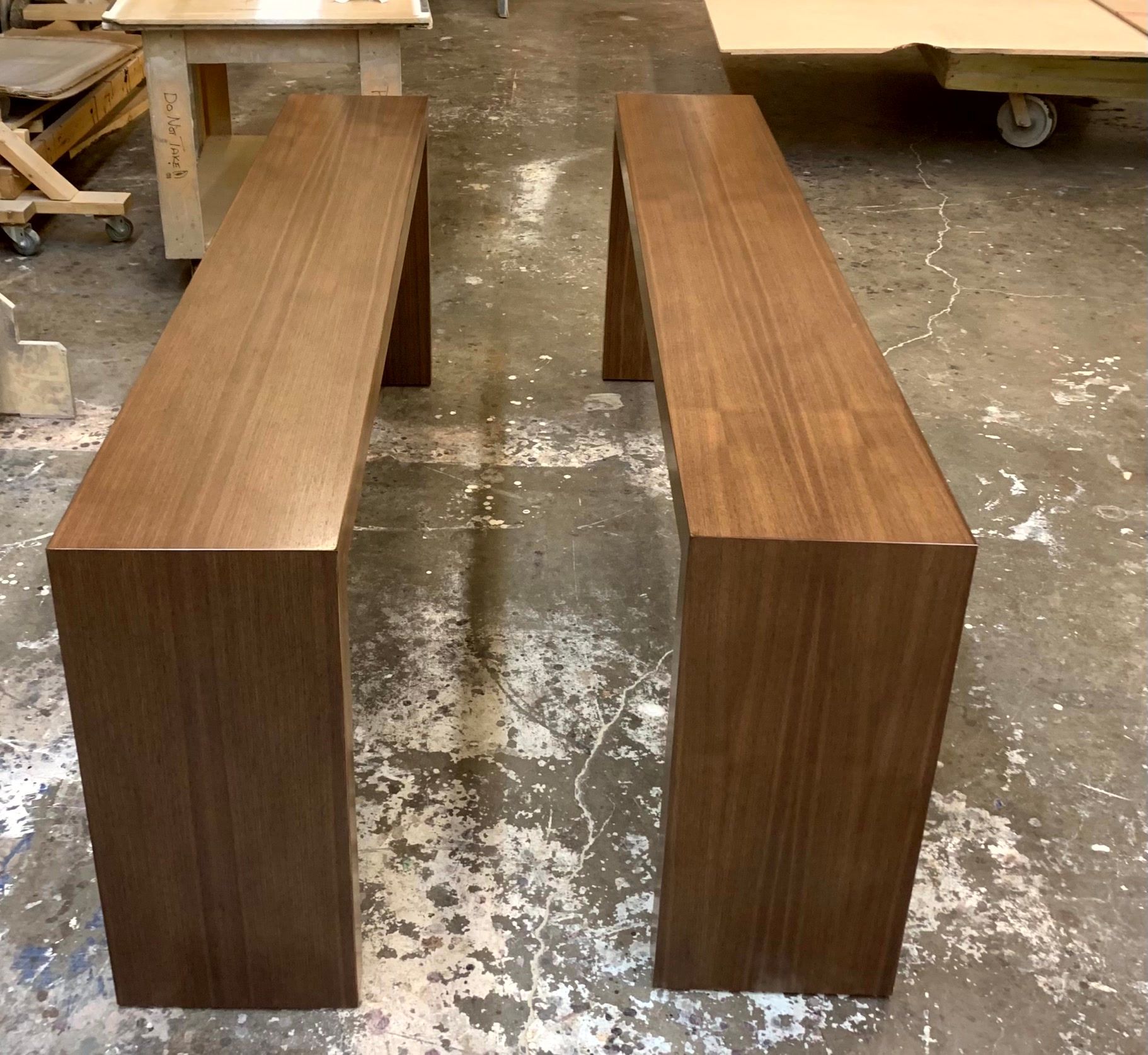 Two wooden benches are sitting next to each other on a concrete floor