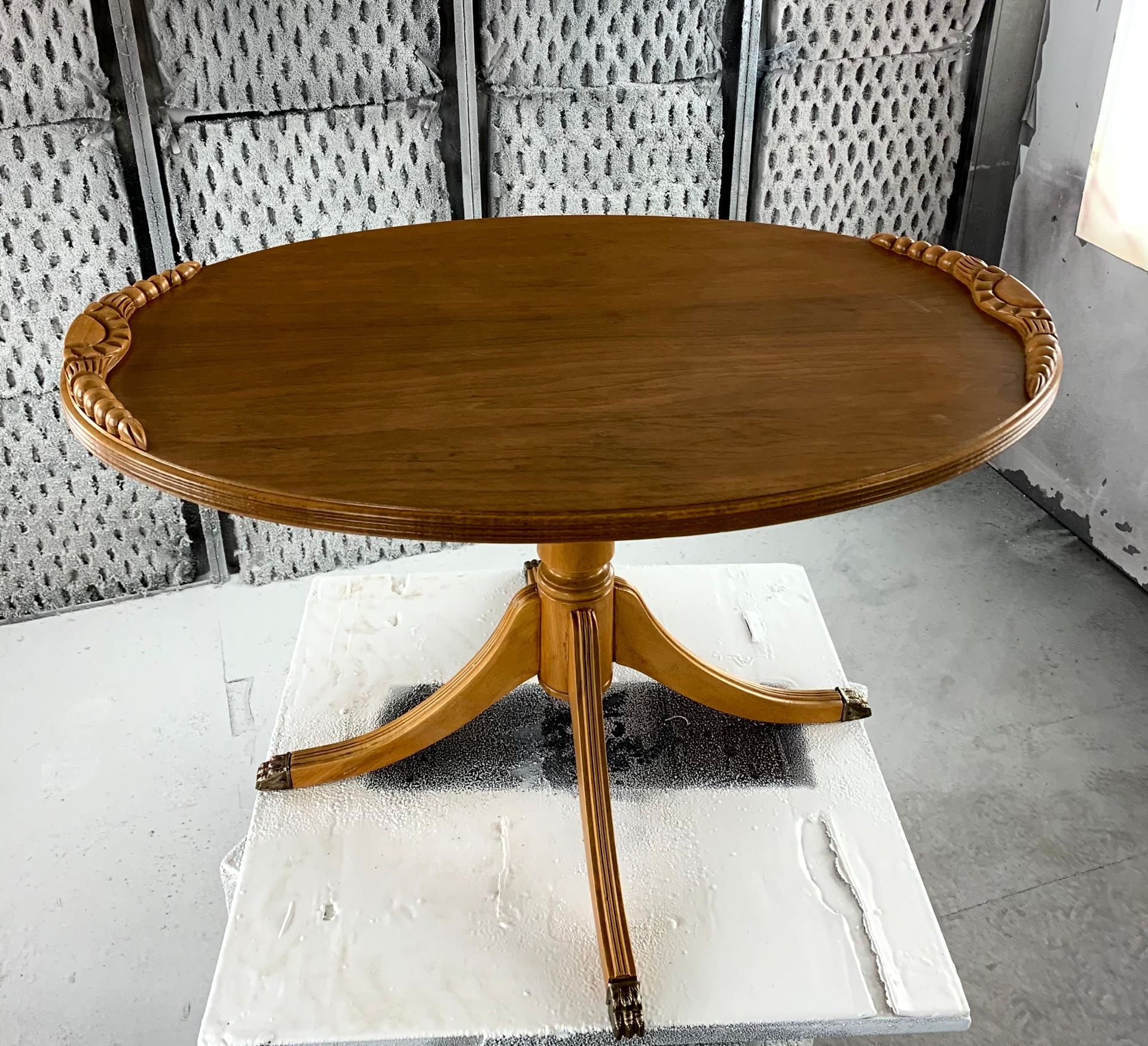 A wooden table is sitting on top of a white table in a room.
