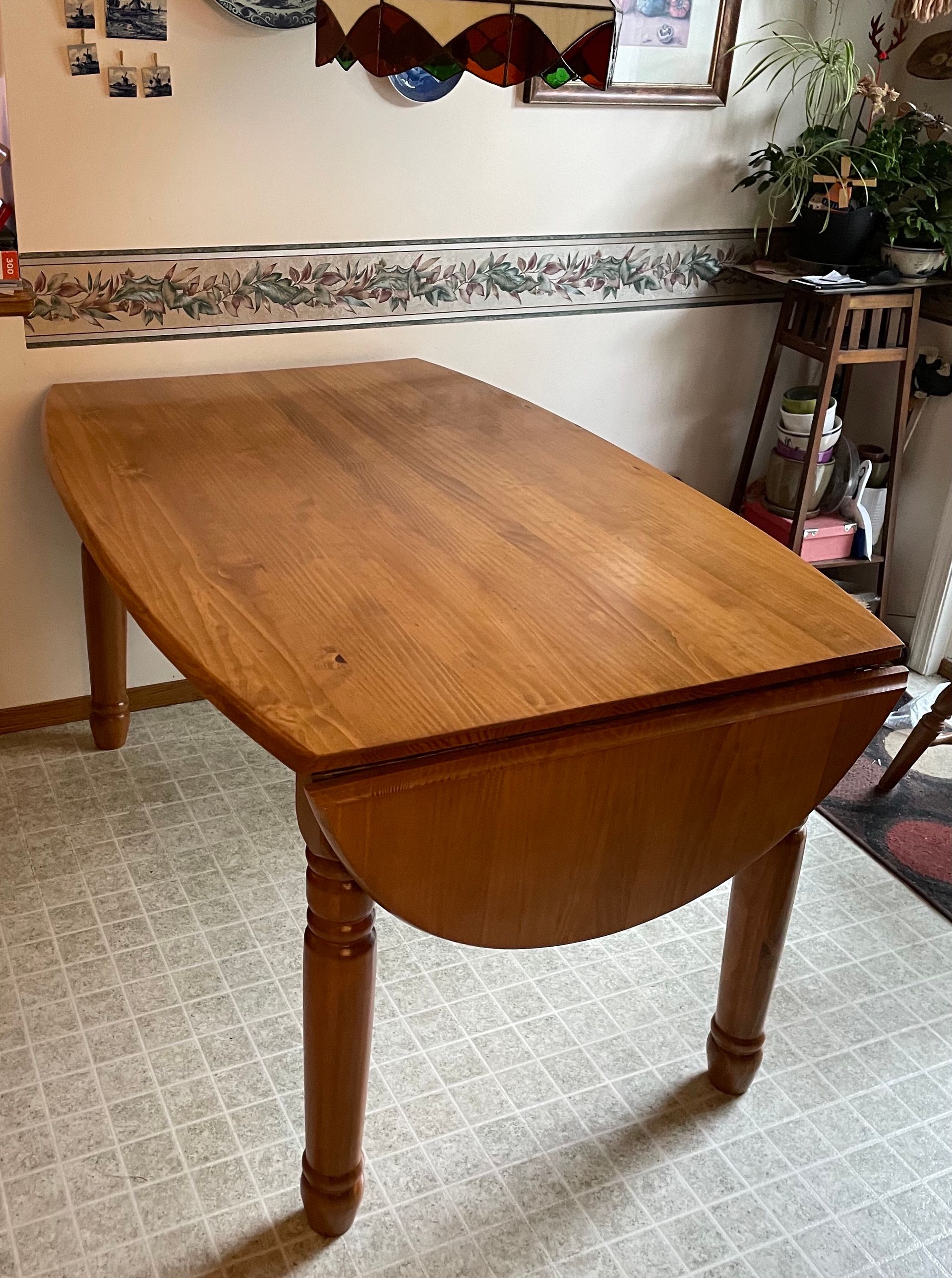 A wooden table is sitting on a tiled floor in a room.