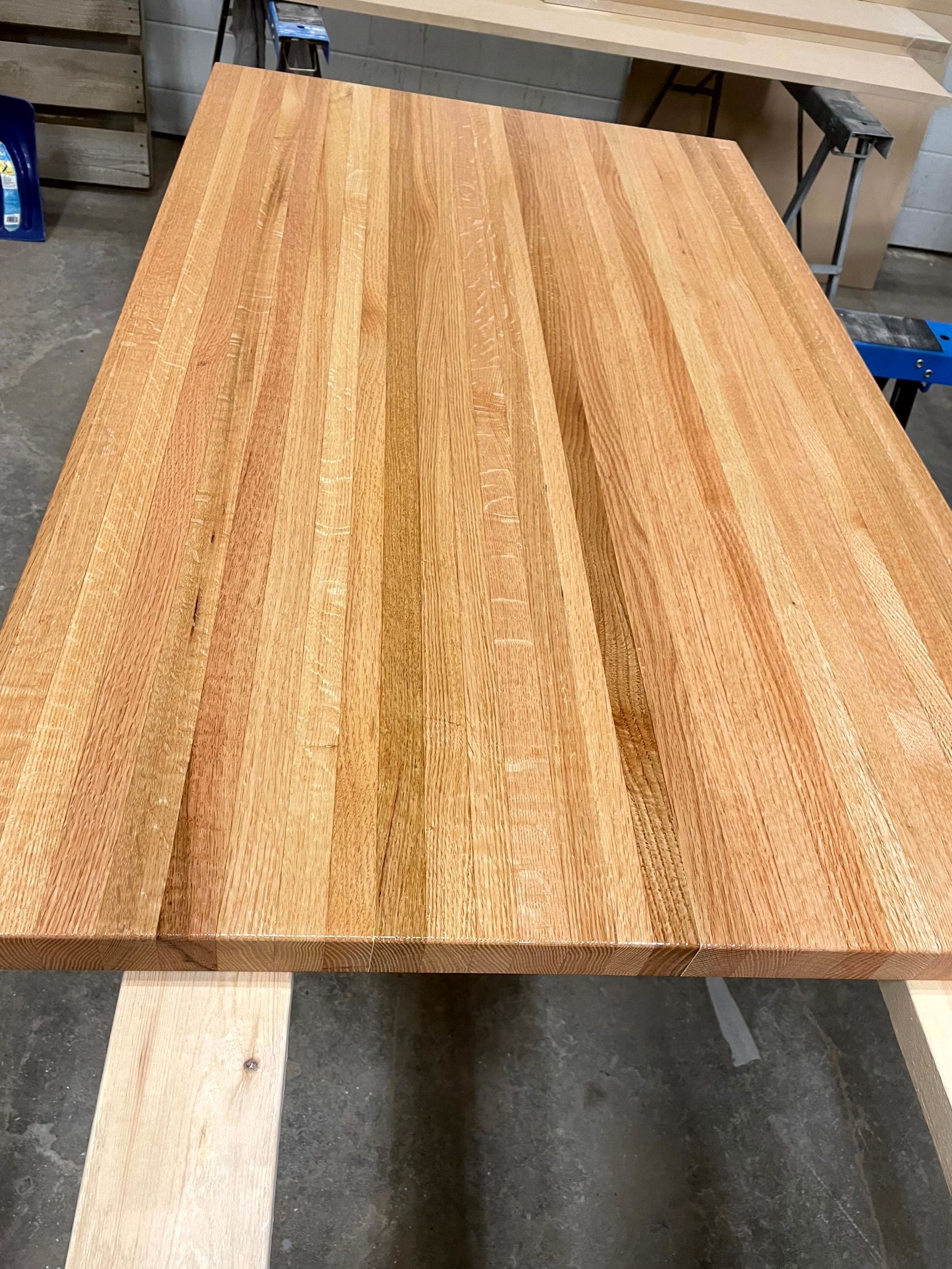 A wooden table is sitting on top of a concrete floor.
