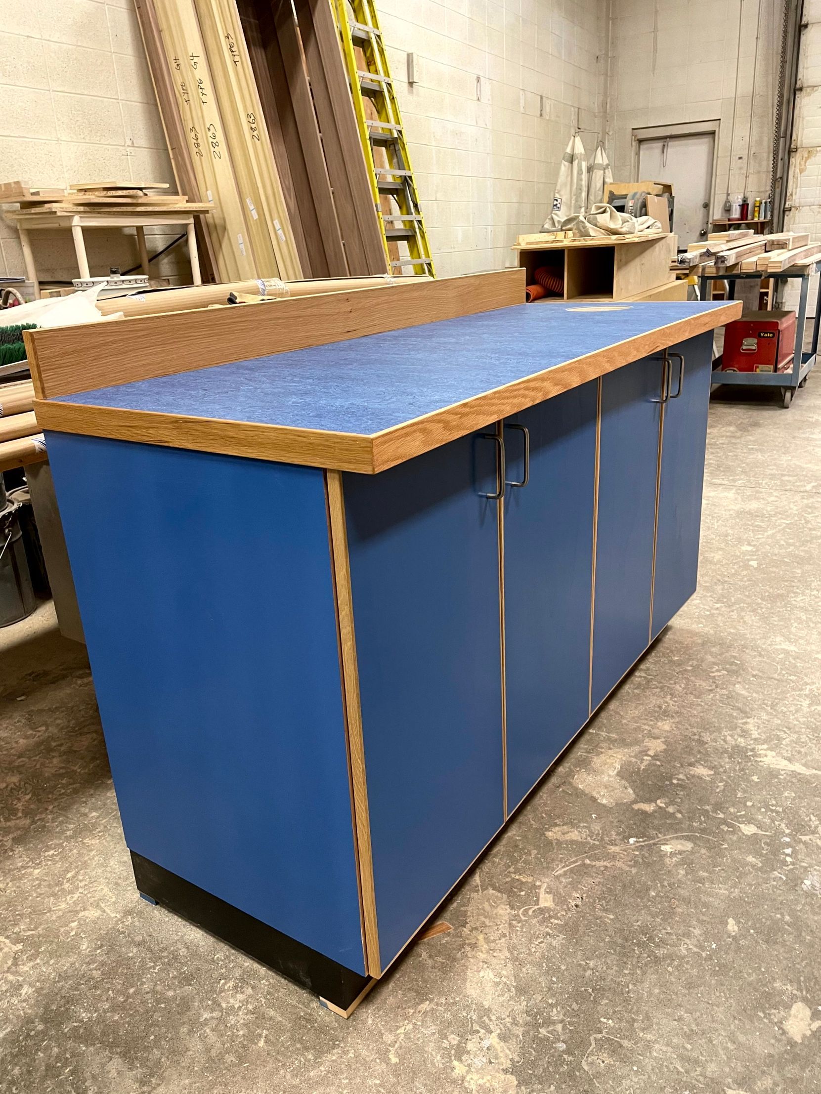 A blue cabinet with a wooden top is sitting in a room.