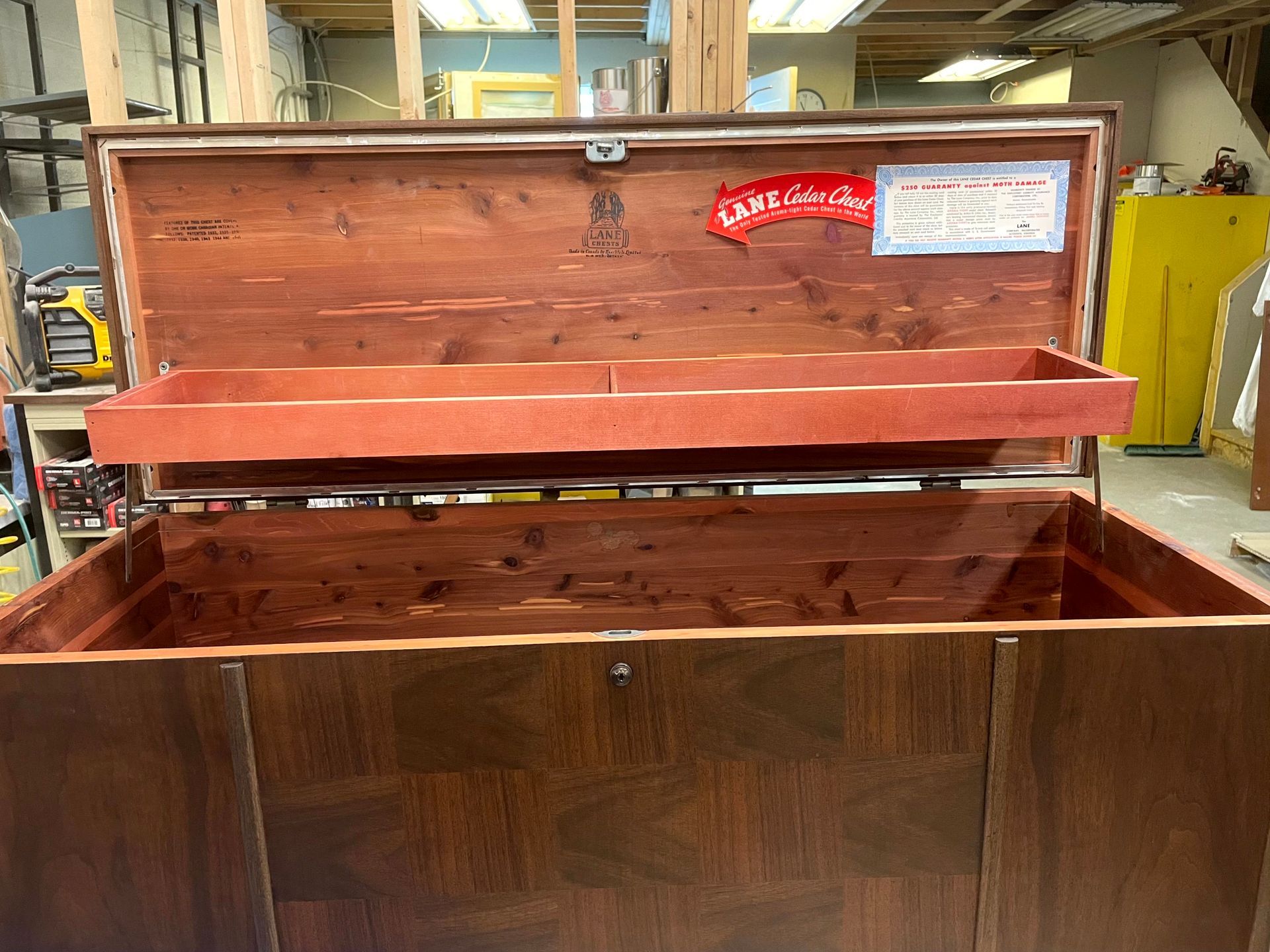 A large wooden chest with the lid open in a room.