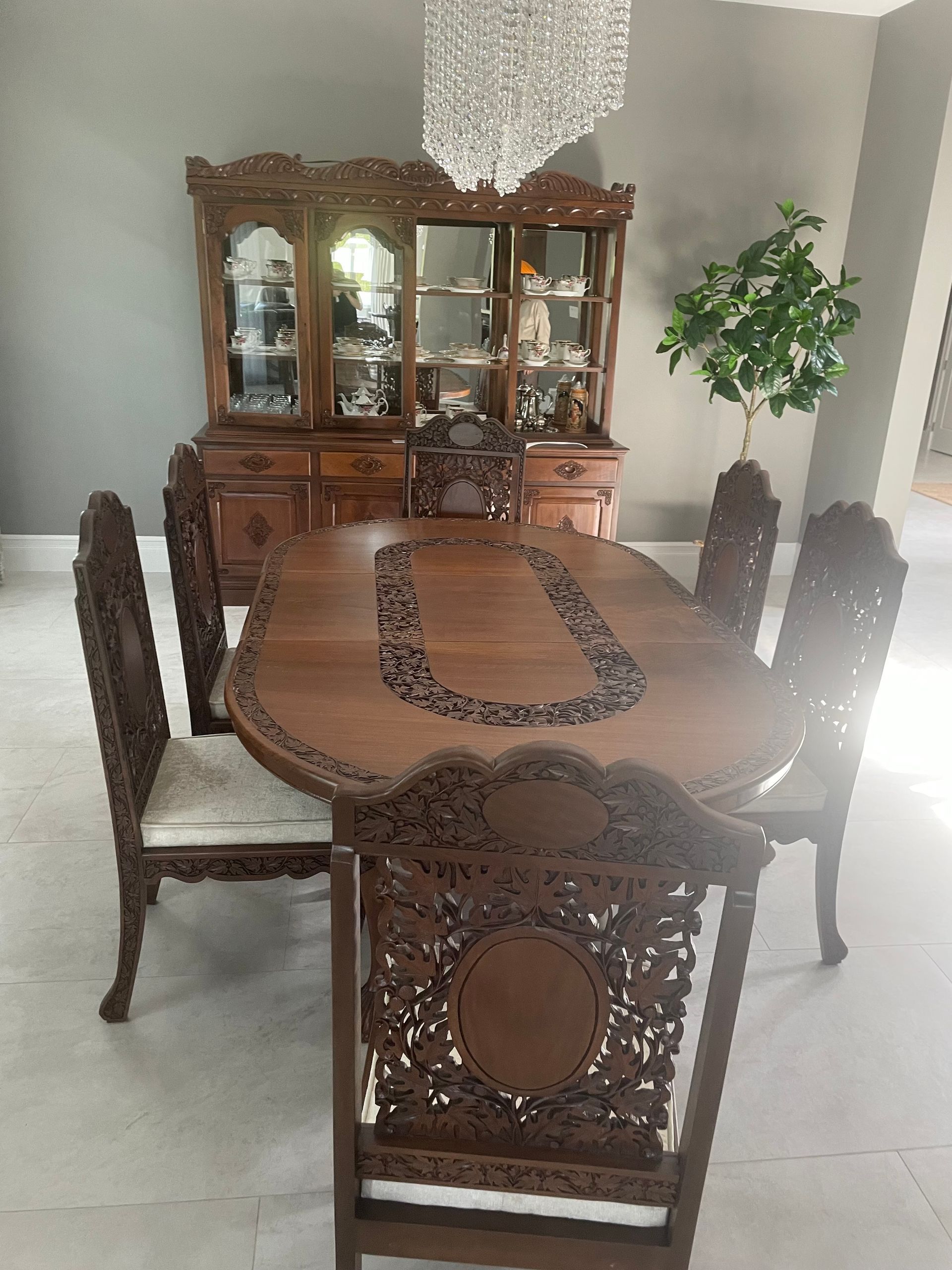A dining room with a table and chairs and a hutch.