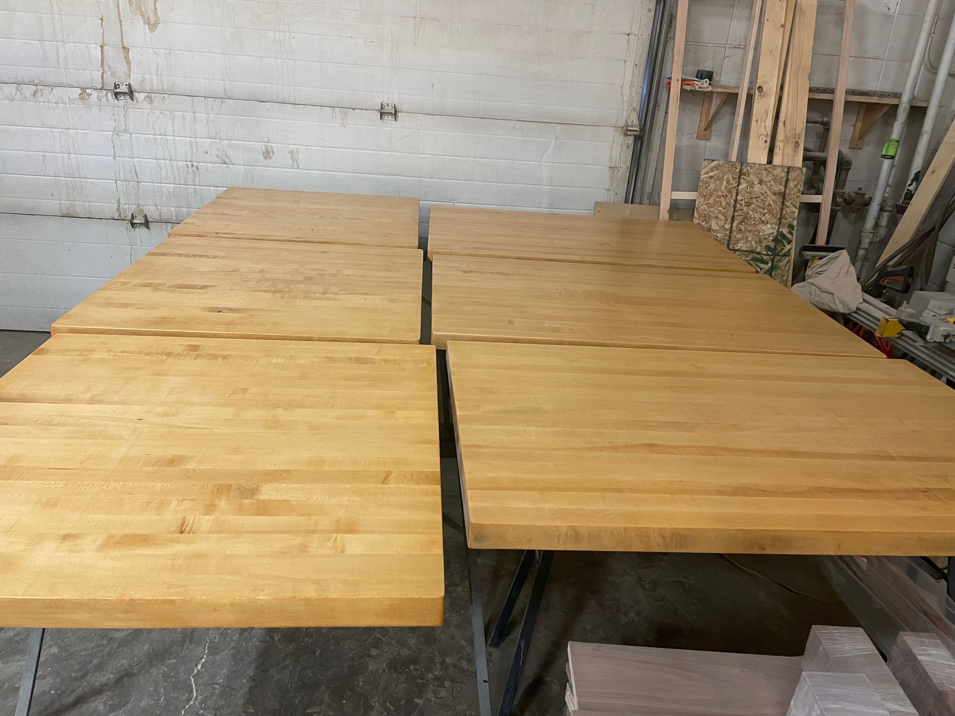 A row of wooden tables are sitting on top of each other in a room.