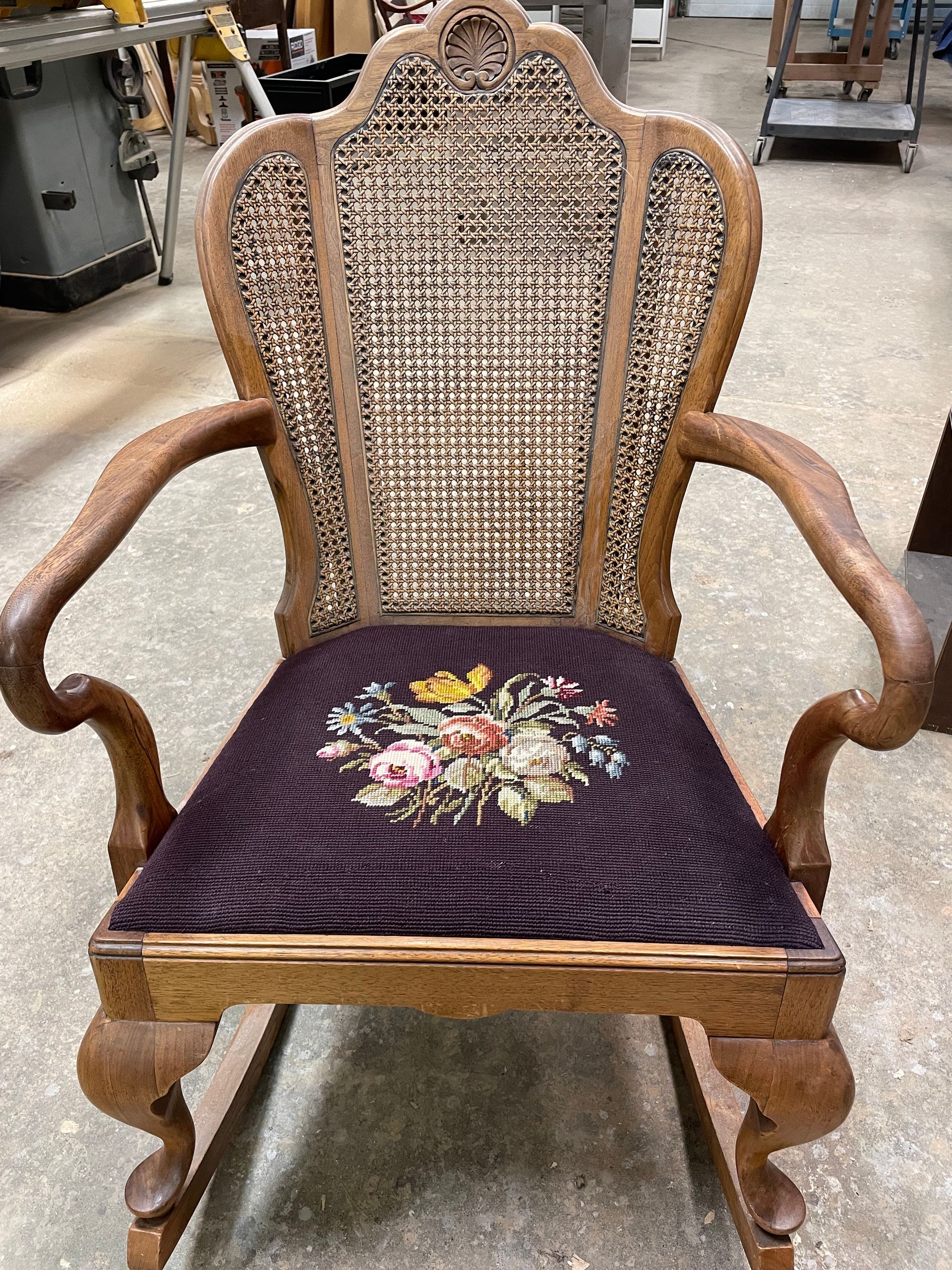 A wooden rocking chair with a purple cushion in a room.
