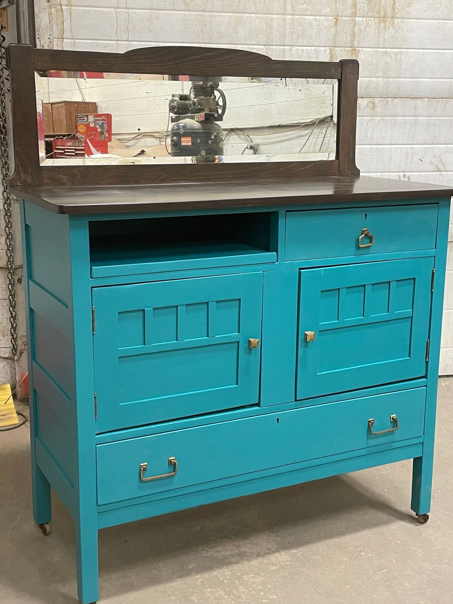 A blue dresser with a mirror on top of it