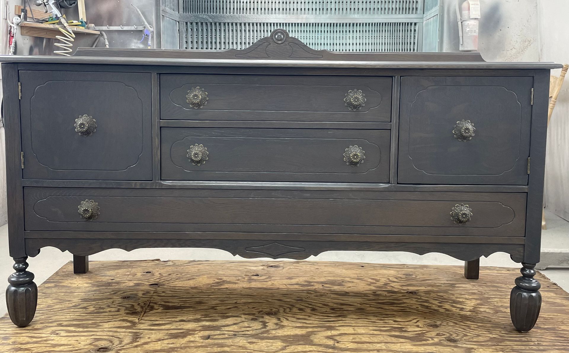 A black dresser with drawers is sitting on a wooden floor.