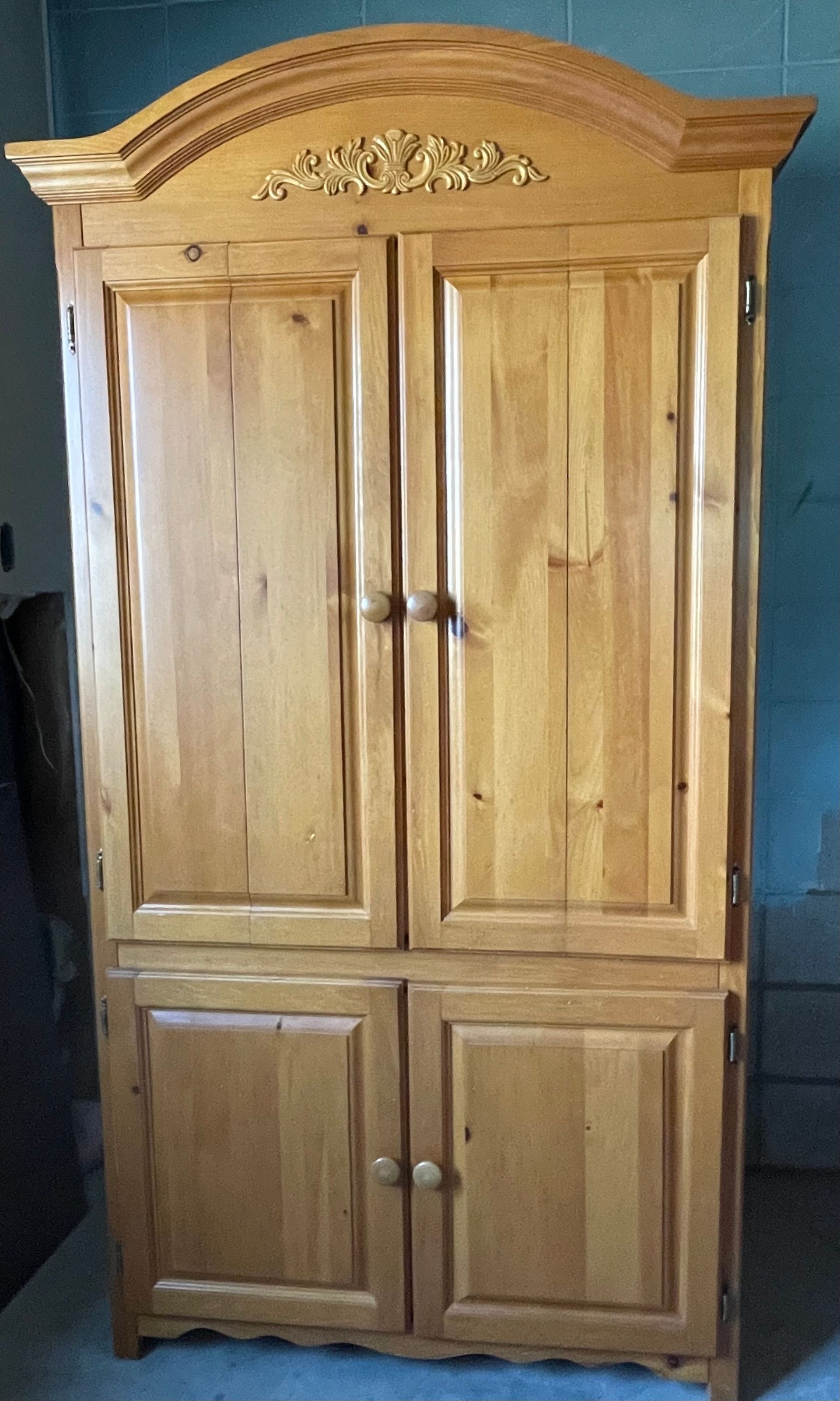 A wooden cabinet with two doors and a crown on top