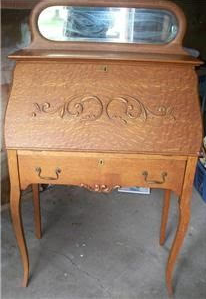A wooden desk with a mirror on top of it.