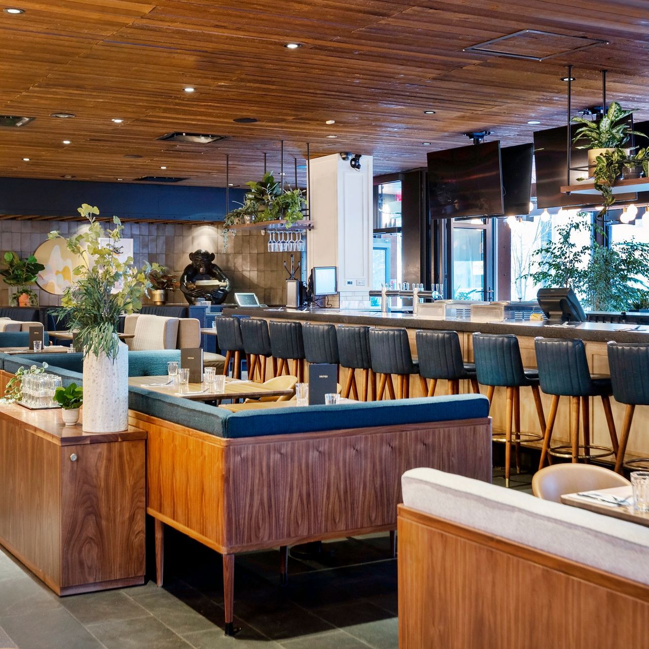 A restaurant with a wooden ceiling and tables and chairs