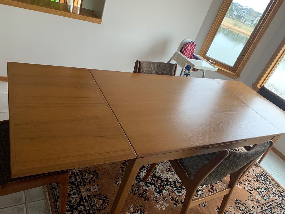 A wooden table and chairs in a room with a window