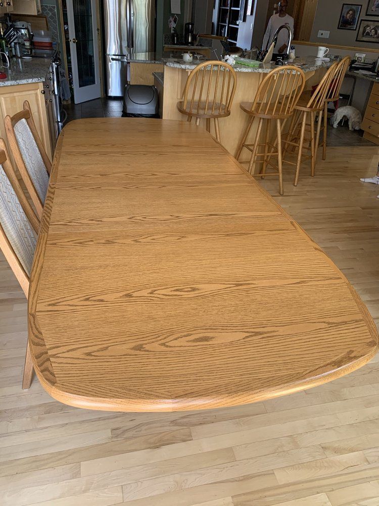 A wooden dining table with chairs in a kitchen.