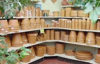 Shelves of stacked terracotta pots and saucers in a garden store display