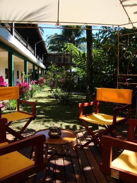 Um pátio com cadeiras e uma mesa sob um guarda-sol