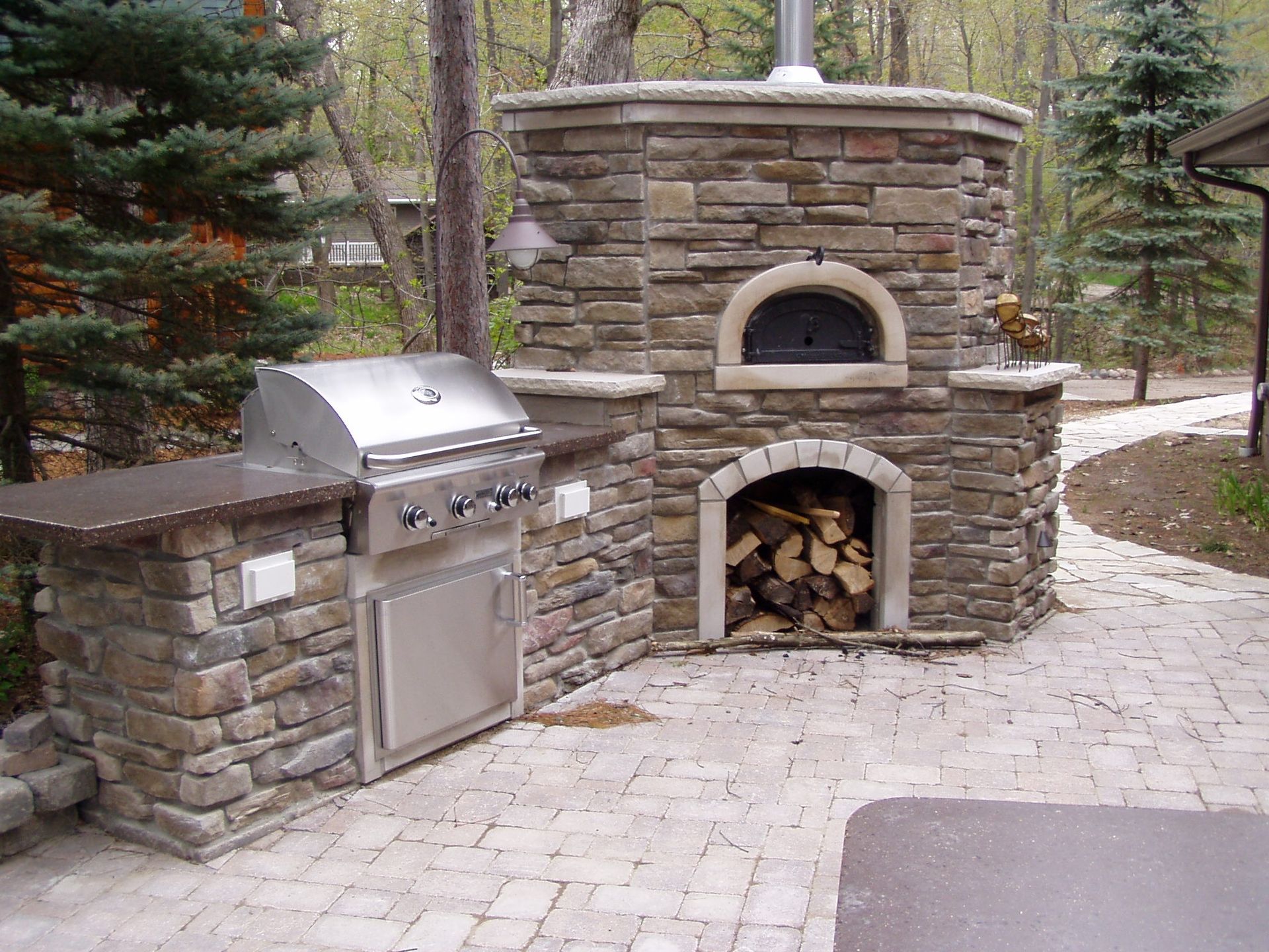 A grill and oven are built into a stone wall