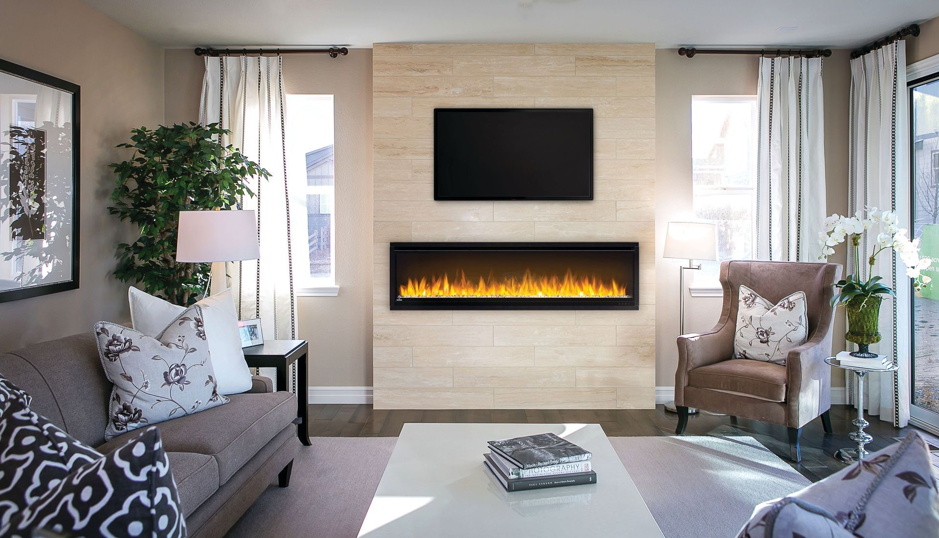 A bottle of wine sits on a table in front of a fireplace