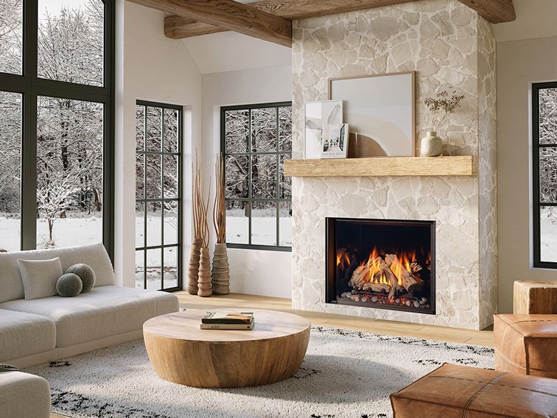 A fireplace with a stone wall and a rug in front of it