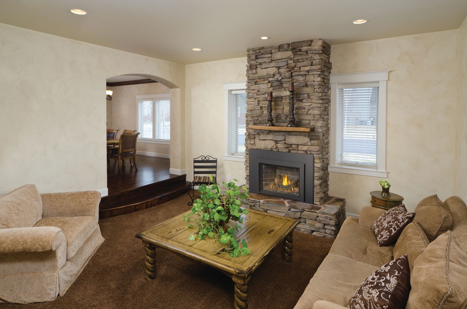 A living room with a brick wall and a fireplace