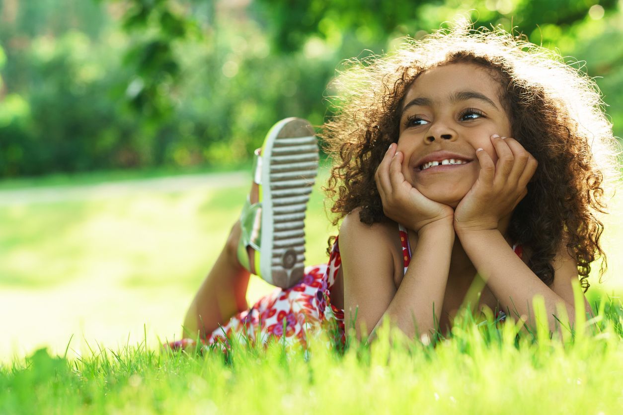 Smiling girl sitting in the grass