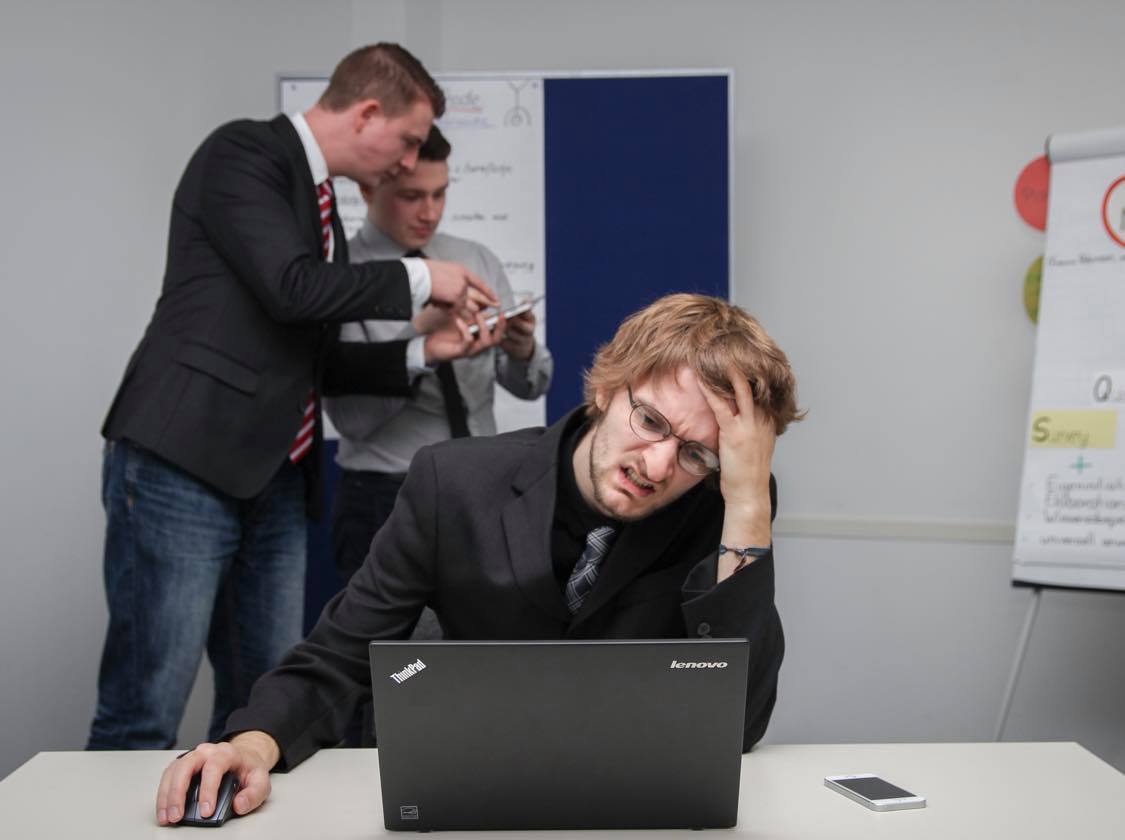 A man sitting at a desk using a lenovo laptop