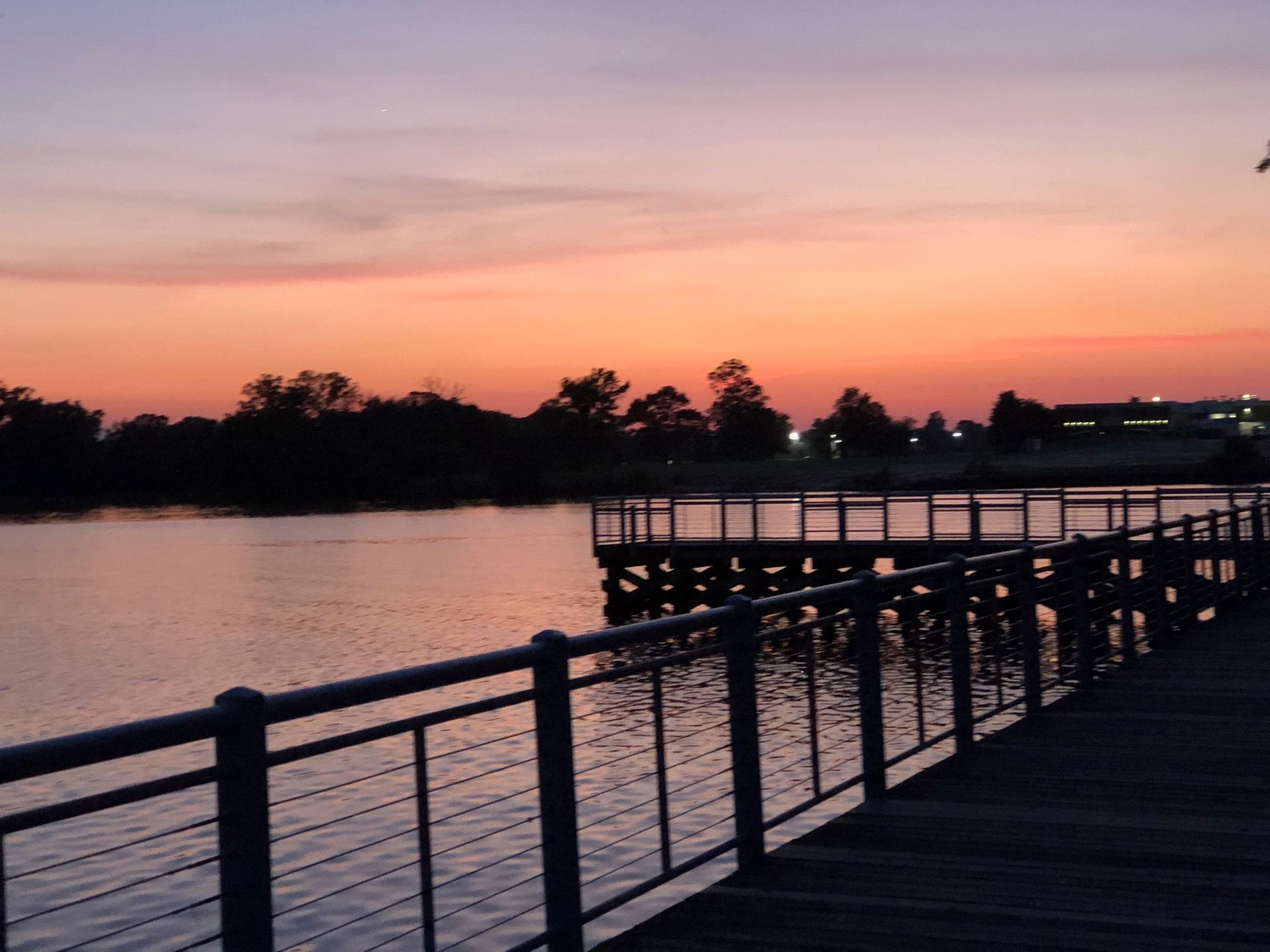 A sunset over a body of water with a dock in the foreground omni-roof.com service area middle river
